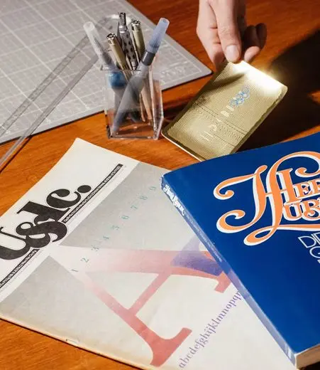 Un bureau de graphiste : revue, règle et crayons.