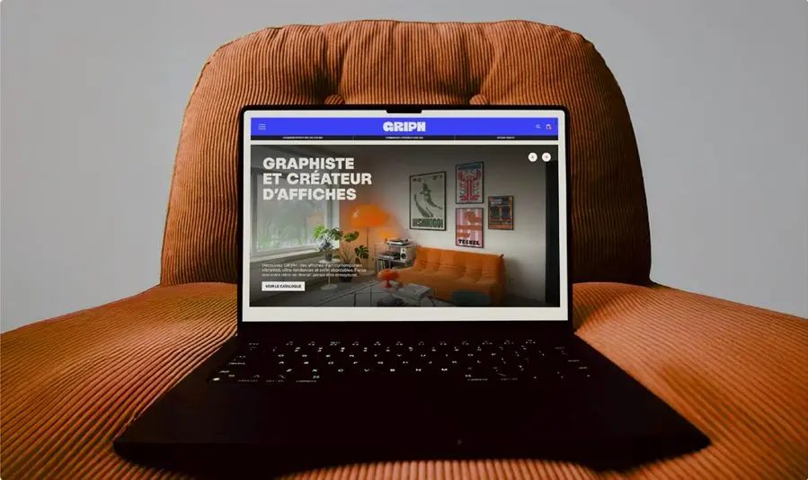La page d'accueil du site GRIPH sur un ordinateur portable posé sur un fauteuil.