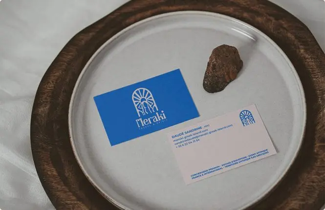 Cartes de visite Meraki, bleue et blanche, posées dans une assiette en céramique.